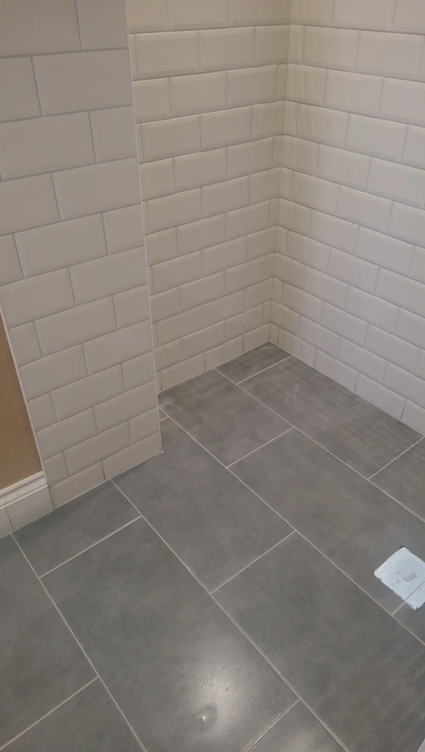 Gray floor tiles and white wall tiles in a new bathroom installation
